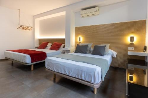 a hotel room with two beds and a television at Apartamentos enfrente del Museo Dalí - Serena Stays in Figueres