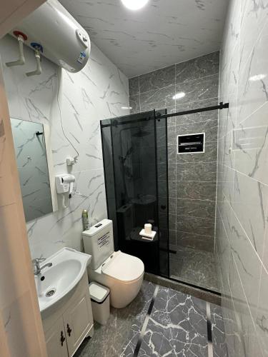 a bathroom with a shower and a toilet and a sink at Лесник in Cholpon-Ata