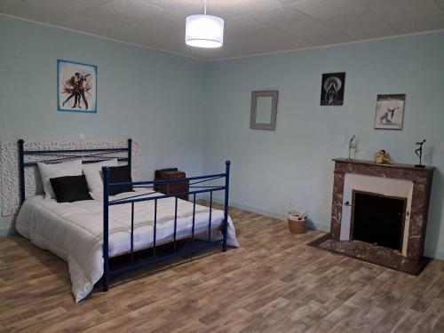 a bedroom with a bed and a fireplace at Gîte La Maison des Arts in Jaunay-Marigny