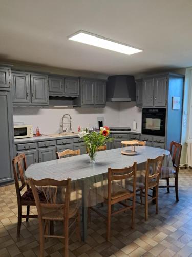 a kitchen with a table with chairs and a kitchen withuclear at Gîte La Maison des Arts in Jaunay-Marigny