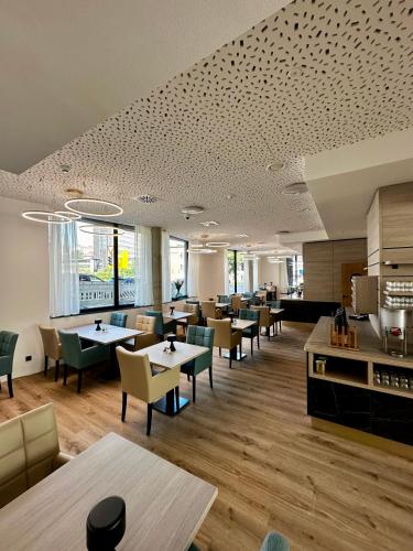 a restaurant with tables and chairs and a cafeteria at Central Hotel in Flensburg