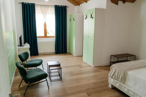 a bedroom with two green chairs and a bed at Cerma Bucovina in Marginea