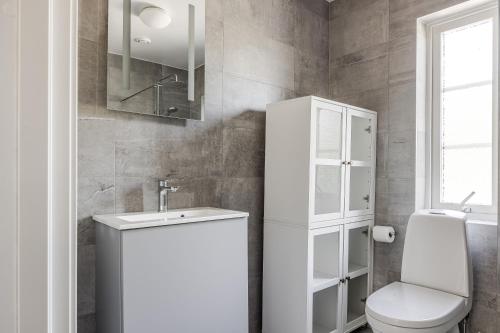a white bathroom with a toilet and a sink at Large and newly built family home in Goteborg in Härryda