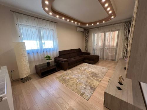 a living room with a leather couch and a rug at Aparthotel Brown in Bucharest