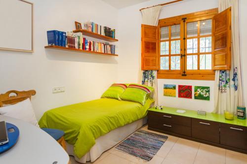 a bedroom with a green bed and a desk at Chalet Monterrey in Real de Gandía
