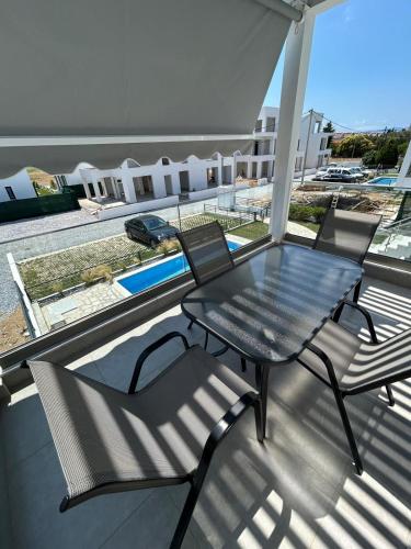 a black table and chairs on a balcony at Olympiada Complex Calma Di Mare Apartment in Ofrínion
