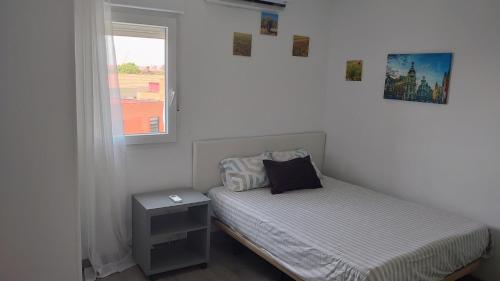 a small bedroom with a bed and a window at Apartamento de 3 habitaciones in Getafe