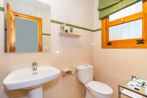 a bathroom with a white toilet and a sink at Chalet Monterrey in Real de Gandía