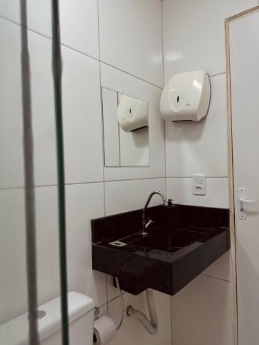 a bathroom with a black sink and a toilet at Nox Temporada Flat Completo em Caruaru com Ar e Wi-Fi Flat 101 in Caruaru