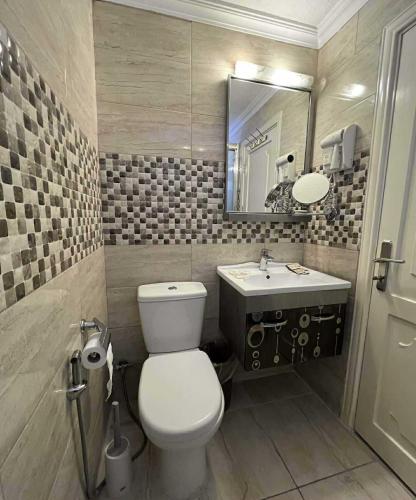 a bathroom with a toilet and a sink and a mirror at Mass Plaza Hotel in Aqaba