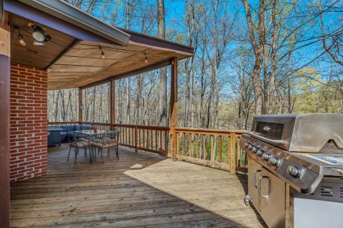 a wooden deck with a grill and a picnic table on it at Ma-ple Haven --Wifi, Fireplace, Deck, Fire Pit, Family Friendly, Game Room, Pool Access in Berkeley Springs