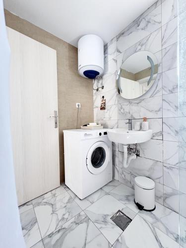 a white bathroom with a washing machine and a sink at House9 in Kotor