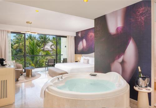 una habitación de hotel con bañera en el medio de una habitación en Desire Riviera Maya Resort All Inclusive - Couples Only, en Puerto Morelos