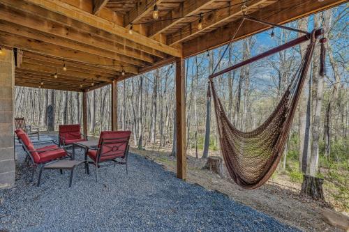 a hammock on a screened in porch with chairs at Ma-ple Haven --Wifi, Fireplace, Deck, Fire Pit, Family Friendly, Game Room, Pool Access in Berkeley Springs