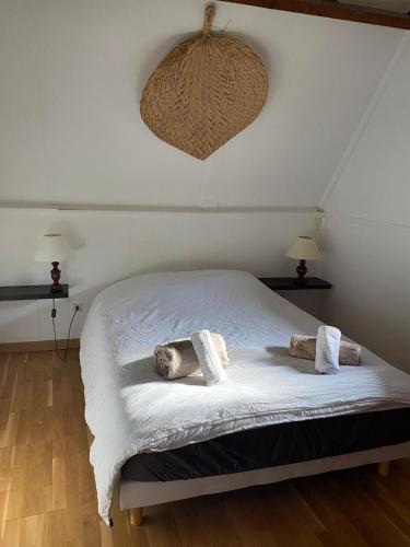 une chambre avec un lit blanc avec deux oreillers dessus dans l'établissement Le gîte du Manoir Normand, à Saint-Philbert-des-Champs