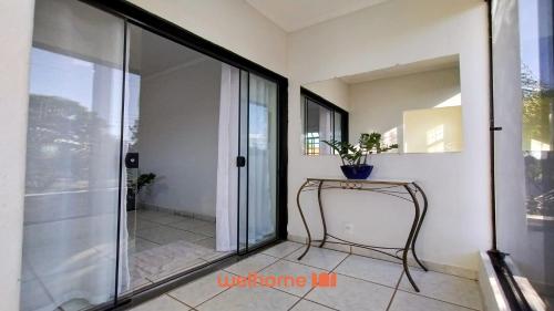 a room with a glass door and a table with a plant at Apartamento em Delfinopolis com Vista Linda in Delfinópolis