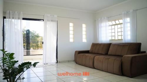 a living room with a couch and a large window at Apartamento em Delfinopolis com Vista Linda in Delfinópolis