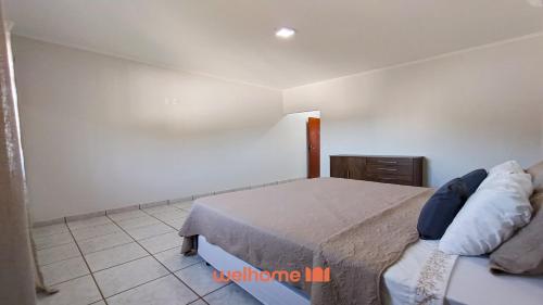 a bedroom with a bed and a tiled floor at Apartamento em Delfinopolis com Vista Linda in Delfinópolis