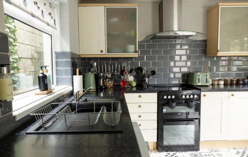 a kitchen with a sink and a stove at Zipworld Waterfalls Eryri Dogs Welcome 3 Bed sleeps 5 in Blaenau-Ffestiniog