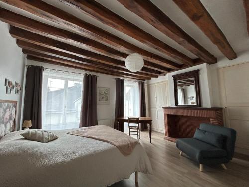 ein Schlafzimmer mit einem Bett und einem blauen Stuhl in der Unterkunft Chez Laurette Les Montils Maison de Bourg in Les Montils