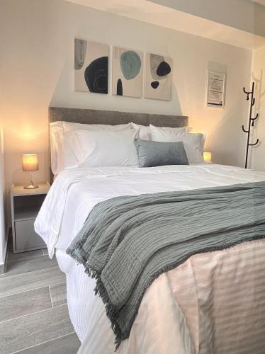 a bedroom with a large white bed with pictures on the wall at BIT by Simple stay in Medellín