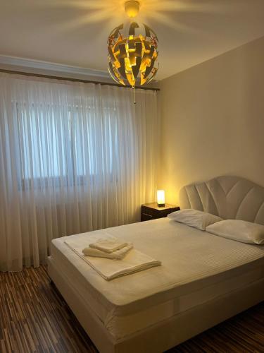 sypialnia z dużym łóżkiem i żyrandolem w obiekcie Aparthotel Brown w Bukareszcie