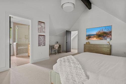 a white bedroom with a bed and a desk at Living My Best Life in Union Pier