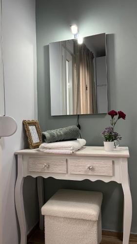 a white dressing table with a mirror in a room at Central Haven in Volos