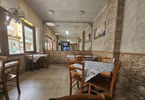 a dining room with tables and chairs in a restaurant at Rooms Avenida in Tavernes de Valldigna