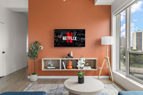 a living room with an orange wall at W603 Luxury 2 Bedroom Top Floor Condo In DT Minneapolis, Minutes From Minneapolis Convention Center & US Bank Arena in Minneapolis