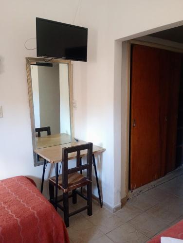 a room with a table and a tv on a wall at Hotel Asembal in Cafayate