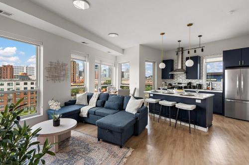 a living room with a blue couch and a kitchen at W603 Luxury 2 Bedroom Top Floor Condo In DT Minneapolis, Minutes From Minneapolis Convention Center & US Bank Arena in Minneapolis