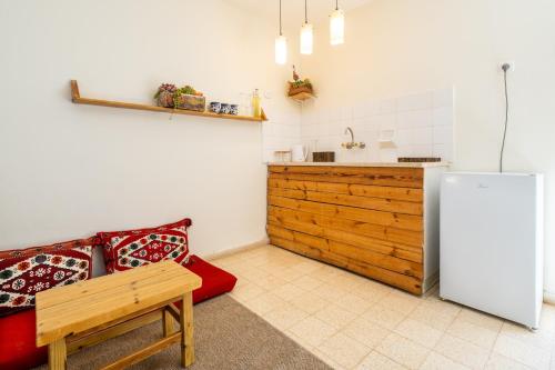a kitchen with a white refrigerator and a red couch at Desert HoM by GLOW in Naẖal Shittim
