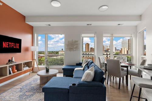 a living room with blue couches and a view of the city at W603 Luxury 2 Bedroom Top Floor Condo In DT Minneapolis, Minutes From Minneapolis Convention Center & US Bank Arena in Minneapolis