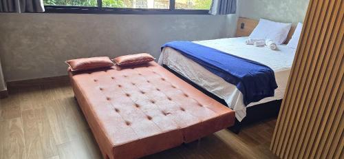 a bed with a large ottoman in a bedroom at City Zen Studios in Sao Jose do Rio Preto