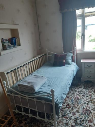 a small bed in a room with a window at Spacious 4 Bedroom House in limerick in Limerick