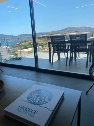 a table and chairs on a balcony with a view at The Artist House - Best Sea View in Porto Rafti in Porto Rafti