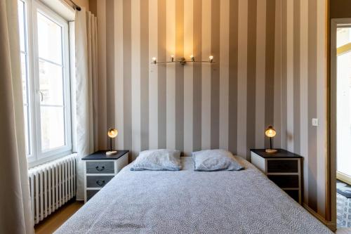 une chambre avec un lit avec deux tables de nuit et deux lampes dans l'établissement Maison de ville au cœur de Saint Pierre en Auge, à Saint-Pierre-sur-Dives