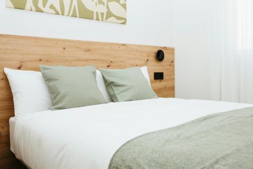 a bed with white sheets and pillows in a bedroom at Hostal Ainhoa in Tafalla