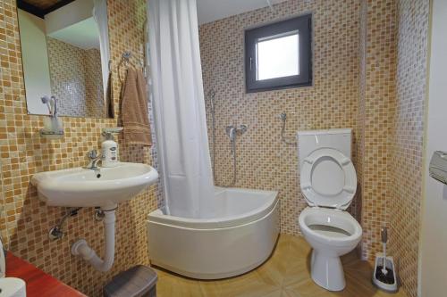 a bathroom with a toilet and a sink and a tub at VILA SMARAGD in Zvornik