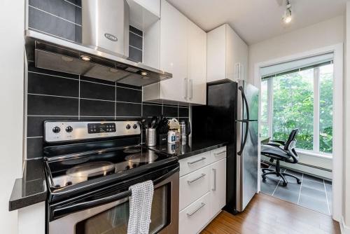 a kitchen with a stove and a refrigerator at Spacious Downtown Condo with Pool Gym & Parking in Vancouver