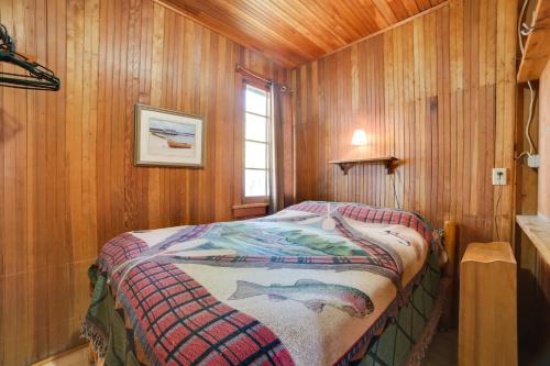 a bedroom with a bed in a wooden room at Fish, Boat and Relax Lakefront Cedarville Cabin 1 in Cedarville
