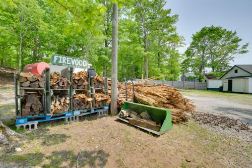 a pile of fire wood next to a pole at Fish, Boat and Relax Lakefront Cedarville Cabin 1 in Cedarville