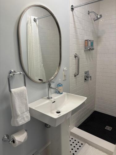 a white bathroom with a sink and a mirror at The Harbor Inn in Kennebunkport