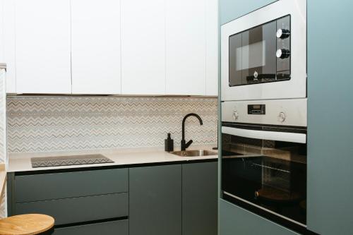 a kitchen with a sink and a microwave at Hostal Ainhoa in Tafalla