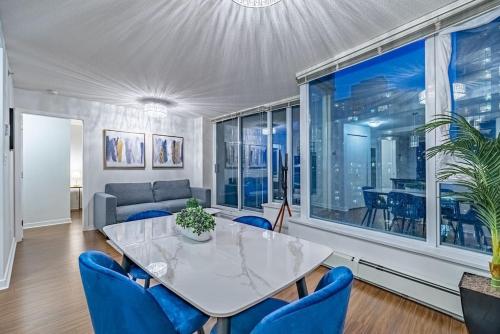a living room with a table and blue chairs at Downtown Condo with Great City Views in Vancouver
