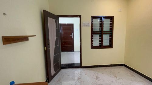 an empty room with a door and a window at KSM Muthra residency in Tiruchchendūr
