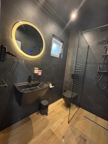 a bathroom with a sink and a shower and a mirror at Vibe Residence Suceava in Suceava