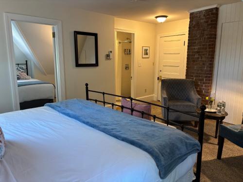 a bedroom with a large bed and a chair at The Harbor Inn in Kennebunkport