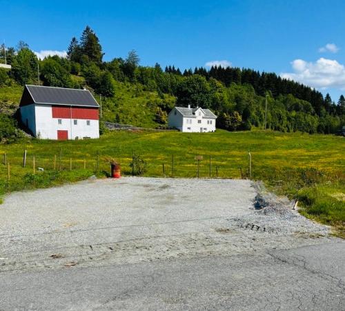 a field with two white houses and a barn at Birdbox Bergen in Bergen